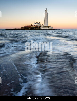 Wellen, Strömung gegenüber der St. Maria Island Causeway in der Dämmerung, mit St Mary's Leuchtturm hinter, auf der Whitley Bay Küste von Tyneside. Stockfoto