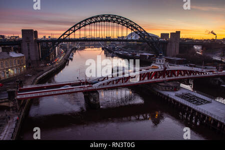 Newcastle, England, Großbritannien - Februar 5, 2019: Die Sonne geht hinter dem ikonischen Tyne Bridge und Brücke zwischen Newcastle und Gateshead auf dem Fluss T Swing Stockfoto