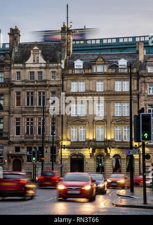 Newcastle, England, Großbritannien - Februar 6, 2019: Ein Bus überquert die Tyne Bridge hoch über die Häuser und Straßen von Newcastle Quayside während des Morgens Stockfoto