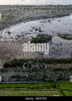 Ein Fahrräder liegt im Watt neben der Gezeiten Themse in Battersea Park im Westen von London aufgegeben. Stockfoto