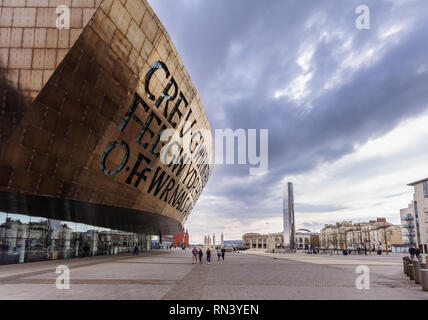 Cardiff, Wales, UK - 17. März 2013: Die markante moderne Architektur von Cardiff Millennium Center Theater dominiert Roald Dahl Plas in der Stadt" Stockfoto