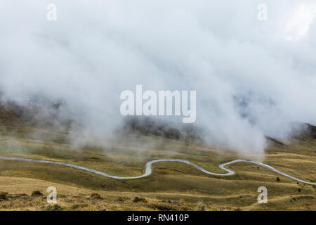 Kurvenreiche Straße unter Nebel bei Giau Pass in Italien Stockfoto