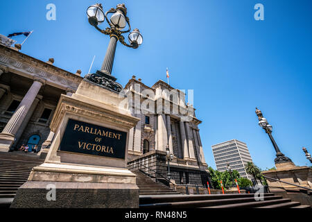 Vorderansicht des Parlament von Victoria mit Namen auf einem Board und alten viktorianischen Straßenlaternen in der Nähe geschrieben in Melbourne, Victoria, Australien Stockfoto