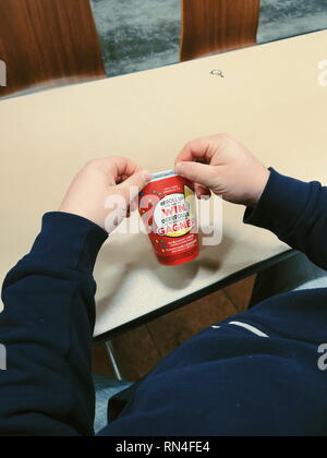 Toronto, Ontario, Kanada - 16. Februar 2019: Mann rollt Rim von Kaffee Pappbecher. Beliebte Kanadische cafeteria Kette Tim Hortons Stockfoto