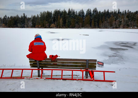 Ein Rettungsschwimmer hält Ausschau nach Menschen, die am 17. Februar 2019 in der Lost Lagoon in Stanley Park, Vancouver, British Columbia, angebrachte dünne Eisschilder ignorieren könnten Stockfoto