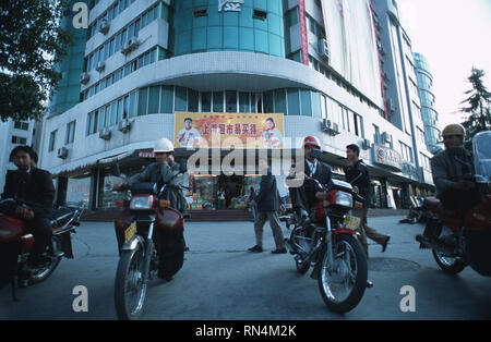 Bildunterschrift: Yichang, Hubei, China - Nov 2002. Motorrad Taxis für die Kunden in der neuen Stadt Yichang, einem der 137 Städte, die Dis wurden warten Stockfoto