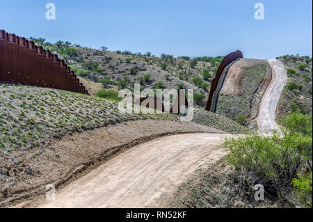 Uns Grenzzaun zu Mexiko Grenze in hügeligem Gelände, Poller Personensperre, von US-Seite nach Westen gesehen, östlich von Nogales Arizona, April 2018 Stockfoto