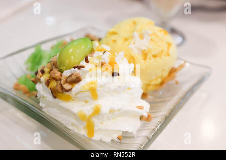 Mango Eis mit Schlagsahne und Mandeln Stockfoto