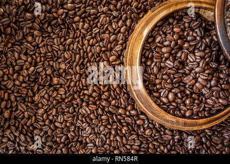 Frisch gerösteten Arabica und Robusta Kaffeebohnen. Kaffee in eine hölzerne Schüssel Stockfoto