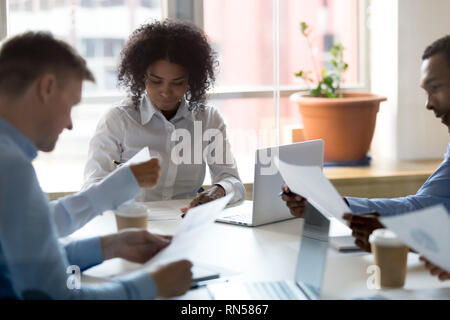 Kolleginnen und Kollegen die Analyse von Statistiken, während im Büro gemeinsam Brainstorming Stockfoto