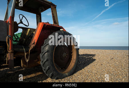 Alte Classic Red farm Traktor auf einem Kieselstrand Stockfoto