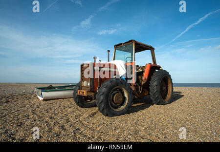 Alte Classic Red farm Traktor auf einem Kieselstrand Stockfoto