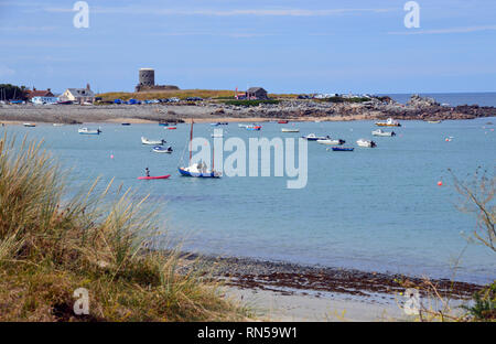 Die Loopholed Martello Rousse Turm mit Blick auf die Fischerboote in Le Grand Havre Bay, Guernsey, Channel Islands.de. Stockfoto