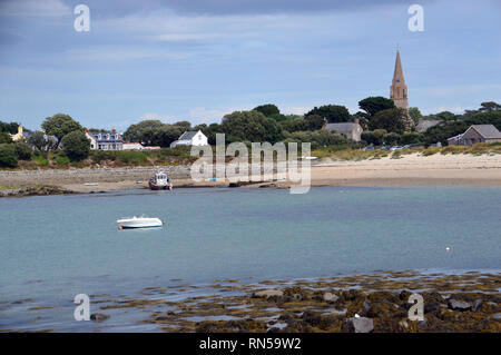 Die Pfarrkirche St. Michel du Valle mit Blick auf die Boote in Le Grand Havre Bay von der Küste weg auf Guernsey, Channel Islands.de. Stockfoto