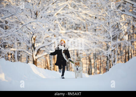 Mädchen gehen Hund in Winter Park Stockfoto
