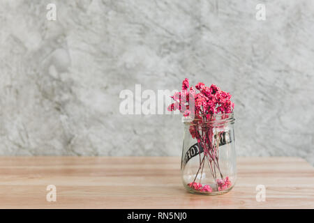 Schöne rosa getrocknete Blumen in Glas Vase auf Holz Tisch in Kaffee Cafe eingerichtet Stockfoto