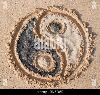 Yin-yang Symbol gezeichnet und mit schwarzen und weissen Sand bei Melasti Beach in Bali, Indonesien gefüllt Stockfoto
