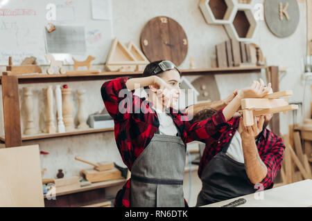 In der Schreinerei coworking studio Kinder und Jugendliche können einen nützlichen Beruf lernen zusammen mit Papa. Es gibt Zimmerei Kurse für Anfänger in Th Stockfoto