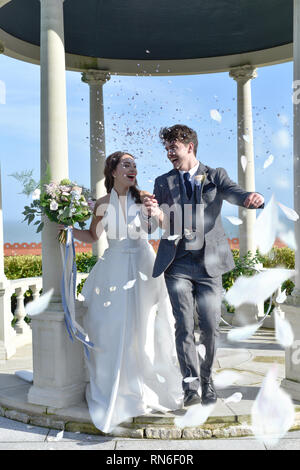 Eine schöne heterosexuelle, weiße, Braut und Bräutigam in einem Hotel am Meer heiraten, sind Sie wirklich glücklich und lachen viel. Die Sonne scheint Stockfoto