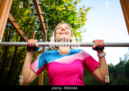 Athlet Mädchen nippen an der Bar im Park im Sommer. Stockfoto