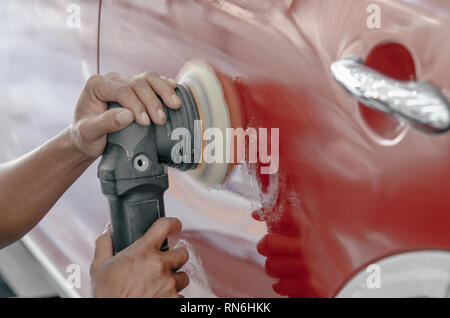 Mann bei der Arbeit Zum polieren, beschichten Autos. Stockfoto