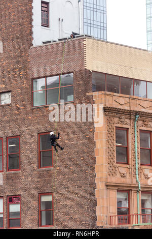 Industrial Engineer Abseilen an der Seite eines Gebäudes in einer strukturellen Inspektion, New York City, USA Stockfoto