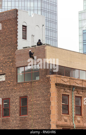 Industrial Engineer Abseilen an der Seite eines Gebäudes in einer strukturellen Inspektion, New York City, USA Stockfoto