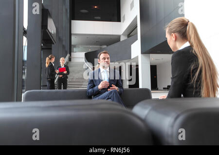 Business Leute, die Sitzen auf einem Sofa im Büro Lobby, Break, interview Konzept Stockfoto