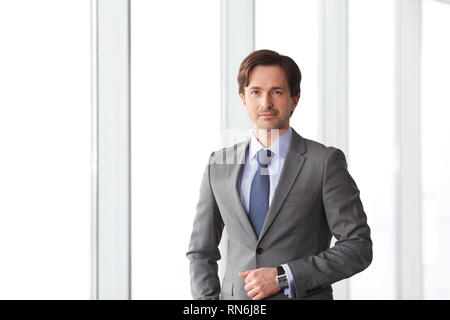Porträt der schönen Geschäftsmann stehen in der Nähe von Windows im Büro Stockfoto
