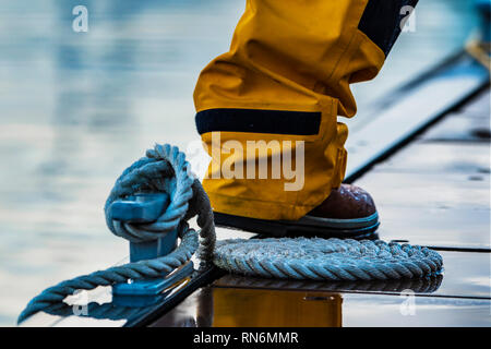 Spiralkabel Verankerungsleine rund klampe gebunden auf einem Ponton an regnerischen Abend. Stockfoto