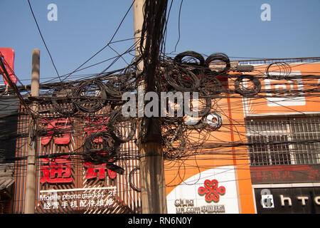 Unordentliche Gewirr von elektrischen und Telefonleitungen auf der Straße Pol. Shanghai, China - 29. Dezember 2014 Stockfoto