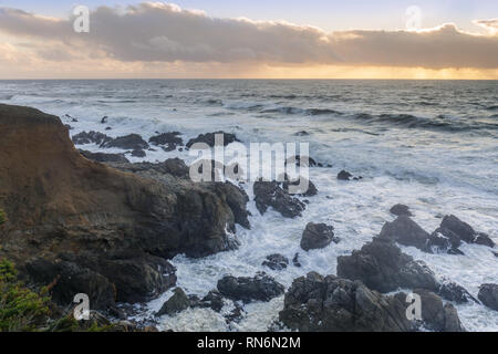 Zerklüftete Küste mit dramatischer Himmel in der Ferne. Stockfoto