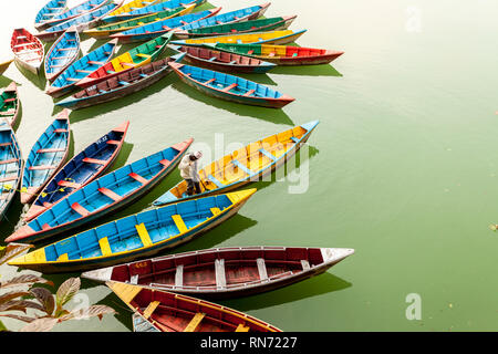 Pokhara, Nepal - November 21, 2015: Reinigung Arbeitnehmer bunte Boote am Phewa See in Pokhara. Stockfoto