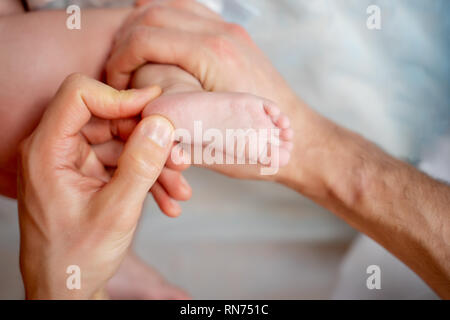 Männlichen Masseur, Massage für Bein des kleinen Kindes, liegen auf dem Tisch. Stockfoto