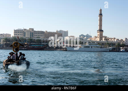 Dicke Dieseldämpfe drift hinter einer der vielen Passagiere, die mit dem Wassertaxi über den Dubai Creek in Dubai in den Vereinigten Arabischen Emiraten (VAE) Stockfoto