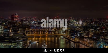 Nacht drone shot Suchen durch die Mitte der Tower Bridge in Richtung St. Paul's Kathedrale. St. Paul's Cathedral in Aussicht, ist abends beleuchtet. Stockfoto