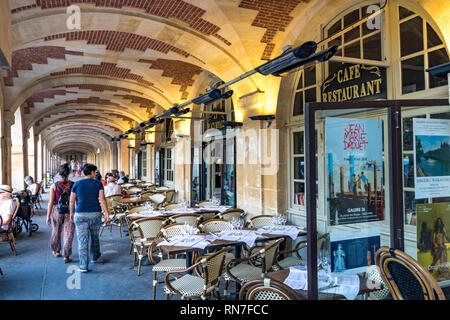 Ein Restaurant unter den Bögen der Place des Vosges, Le Marais. Paris, eine der schönsten Platz in der französischen Hauptstadt. Stockfoto