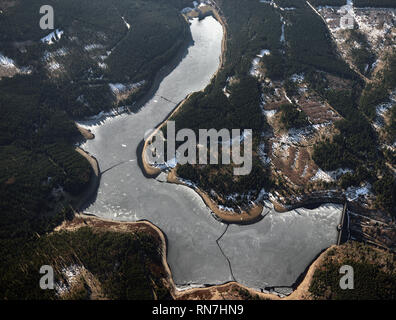 Spektakuläre top Blick auf einem zugefrorenen See im Wald. Winterlandschaft Panorama von Ecker Stausee, Ecker Dam, Harz, Deutschland. Stockfoto