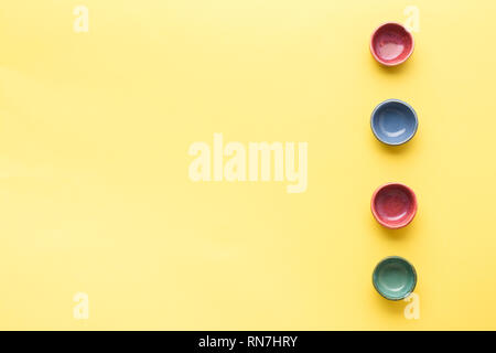 Vier bunte dip Gerichte Förmchen auf gelbem Hintergrund Tabelle, Ansicht von oben, Kopieren, selektiven Fokus Stockfoto