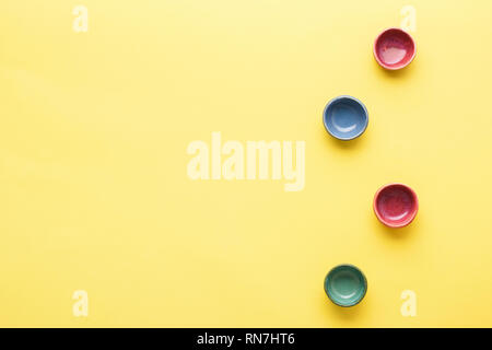 Vier bunte dip Gerichte Förmchen auf gelbem Hintergrund Tabelle, Ansicht von oben, Kopieren, selektiven Fokus Stockfoto