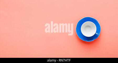 Blau Kaffeetasse und sauser am trendigen Coral Hintergrund Tabelle, Ansicht von oben, Kopieren, selektiven Fokus Stockfoto