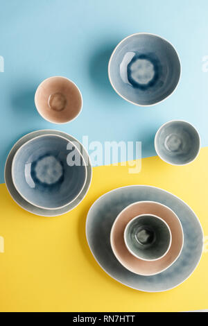 Schöne blau, grau, beige Geschirr, Teller Schalen auf Blau Gelb Hintergrund Tabelle, Ansicht von oben, Kopieren, selektiven Fokus Stockfoto