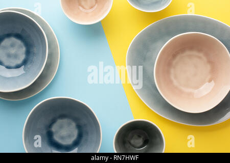 Schöne blau, grau, beige Geschirr, Teller Schalen auf Blau Gelb Hintergrund Tabelle, Ansicht von oben, Kopieren, selektiven Fokus Stockfoto
