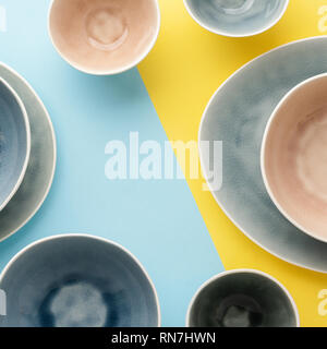 Schöne blau, grau, beige Geschirr, Teller Schalen auf Blau Gelb Hintergrund Tabelle, Ansicht von oben, Kopieren, selektiven Fokus Stockfoto