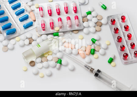 Medizin Pillen, Ampulle, Kapseln und Spritze auf weißem Hintergrund. Ansicht von oben. Stockfoto