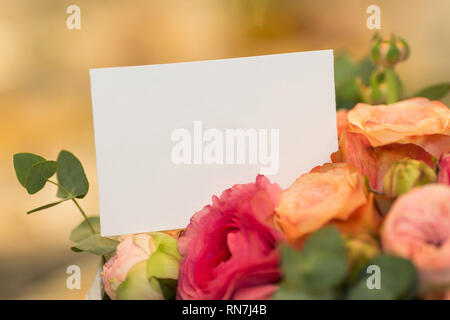 Blumenarrangements, vorliegenden Konzept. In der Nähe der leeren weißen Karte in Blumenstrauß. Stockfoto