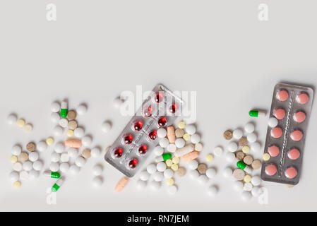 Viele bunte Arzneimittel. Pillen Kapseln und Spritze, Blister auf weißem Hintergrund. Ansicht von oben mit der Kopie Raum, flach. Stockfoto