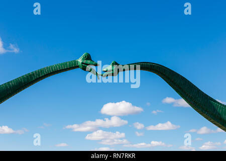 Erenhot, der Inneren Mongolei, China - 23. September 2018: Zwei grüne Dinosaurier vor blauem Himmel zu küssen. Statuen von zwei Dinosaurier, auf beiden Seiten der Straße in der Nähe der Stadt. Stockfoto