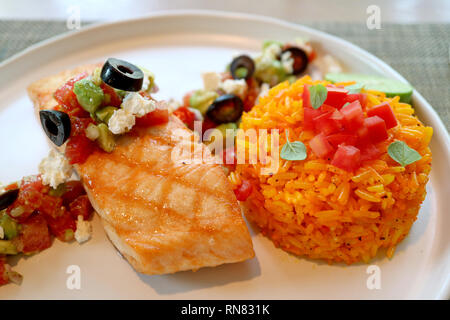 Griechischen Stil in der Pfanne gebratenen Lachs mit Avocado, Tomaten, schwarze Oliven, Feta-Käse Salat und Safran Reis Stockfoto