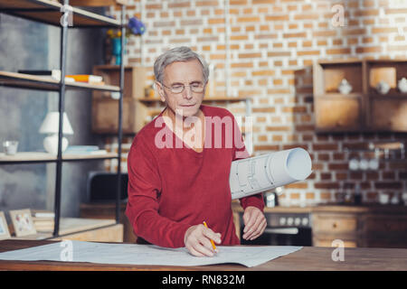 Kontrolle der Grafiken. Ruhe aufmerksam Senior Engineer sorgfältig mit Blick auf die Grafik und Sie prüfen Stockfoto